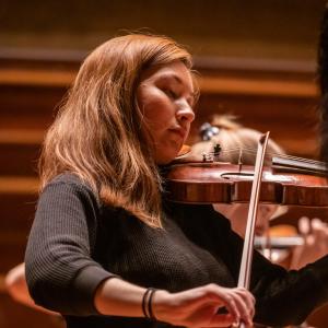 A violinist closes her eyes while playing in Jordan Hall