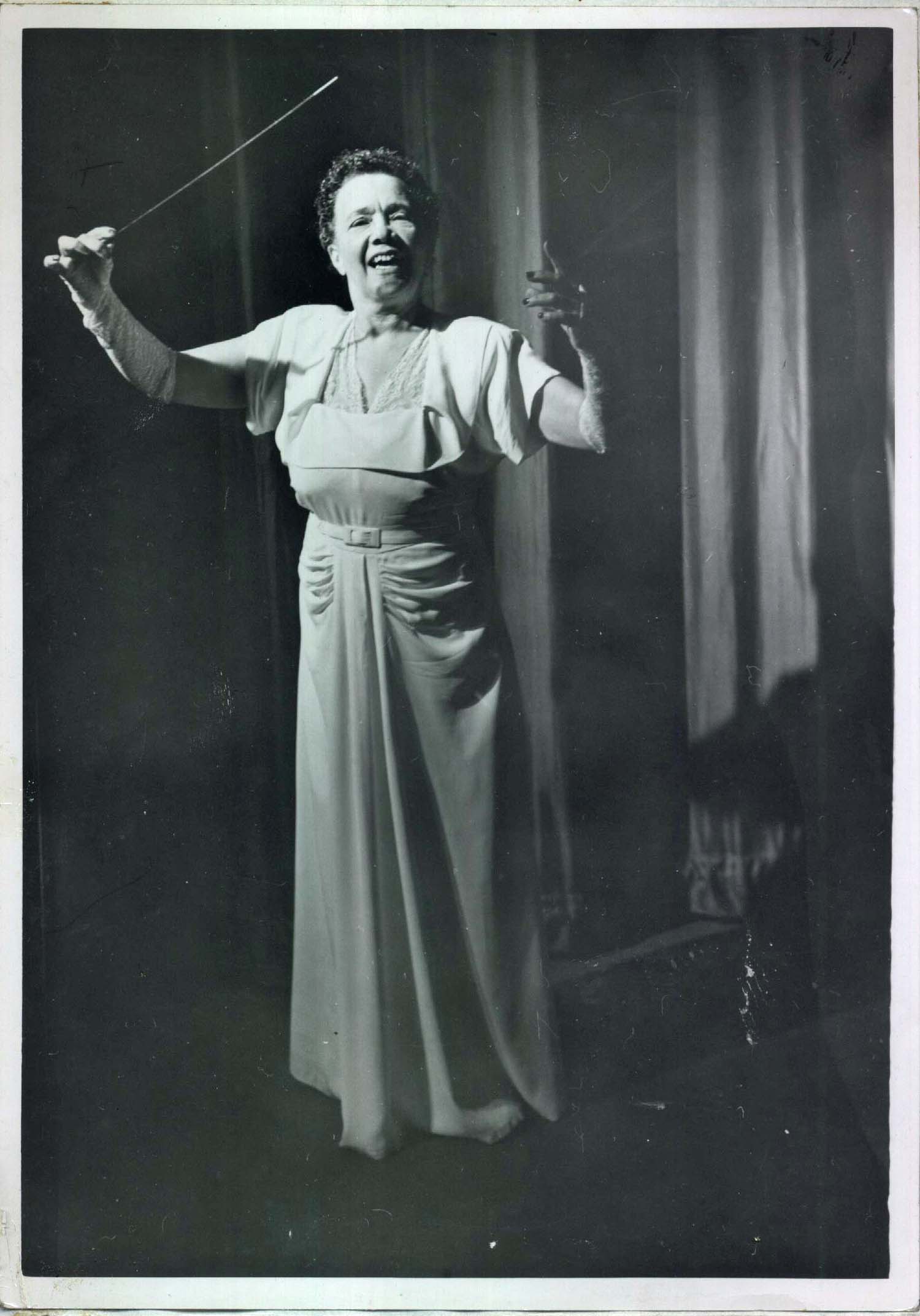 Isabele Taliaferro Spiller smiles broadly while conducting
