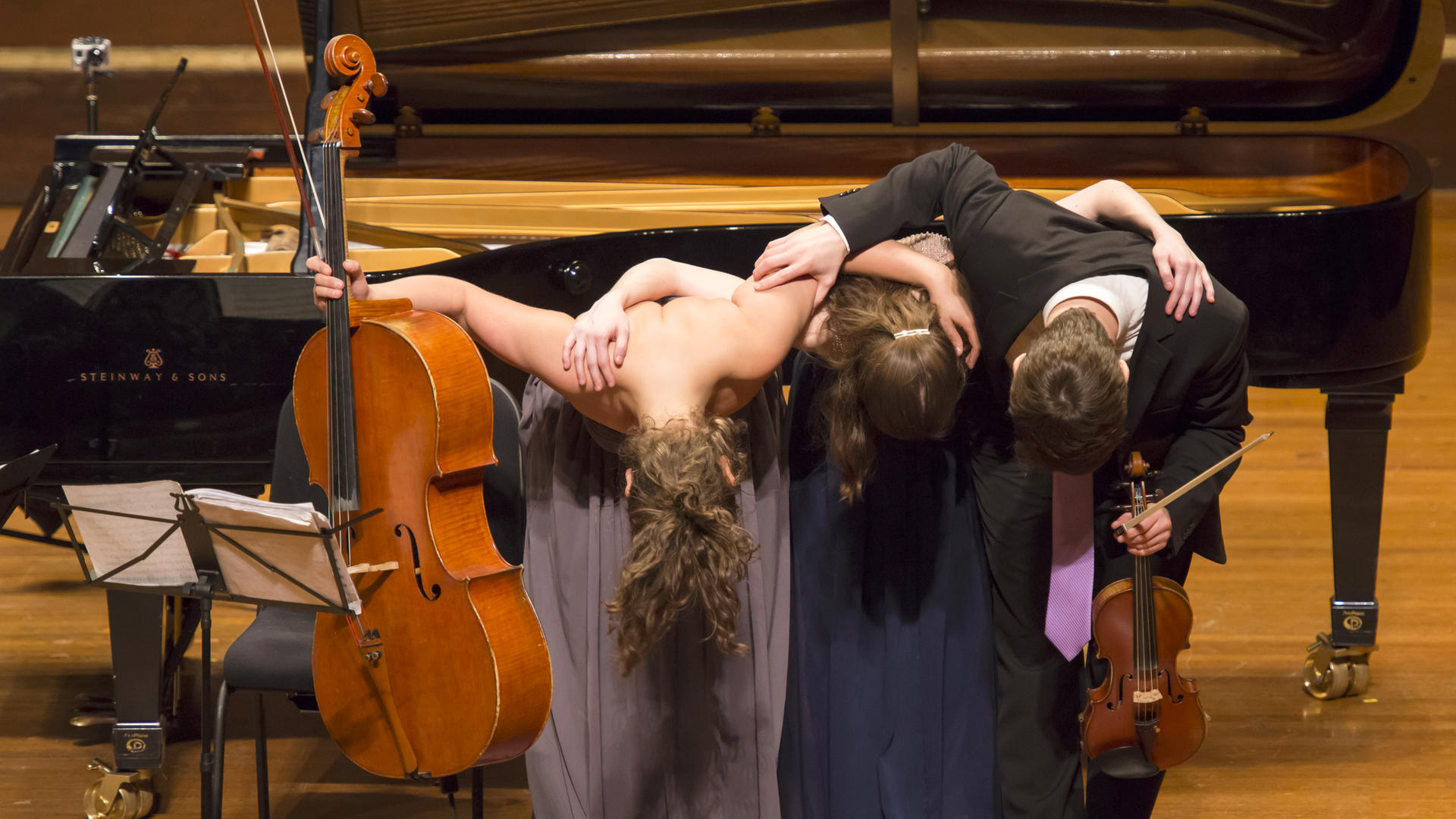 A piano trio bows at the end of a concert