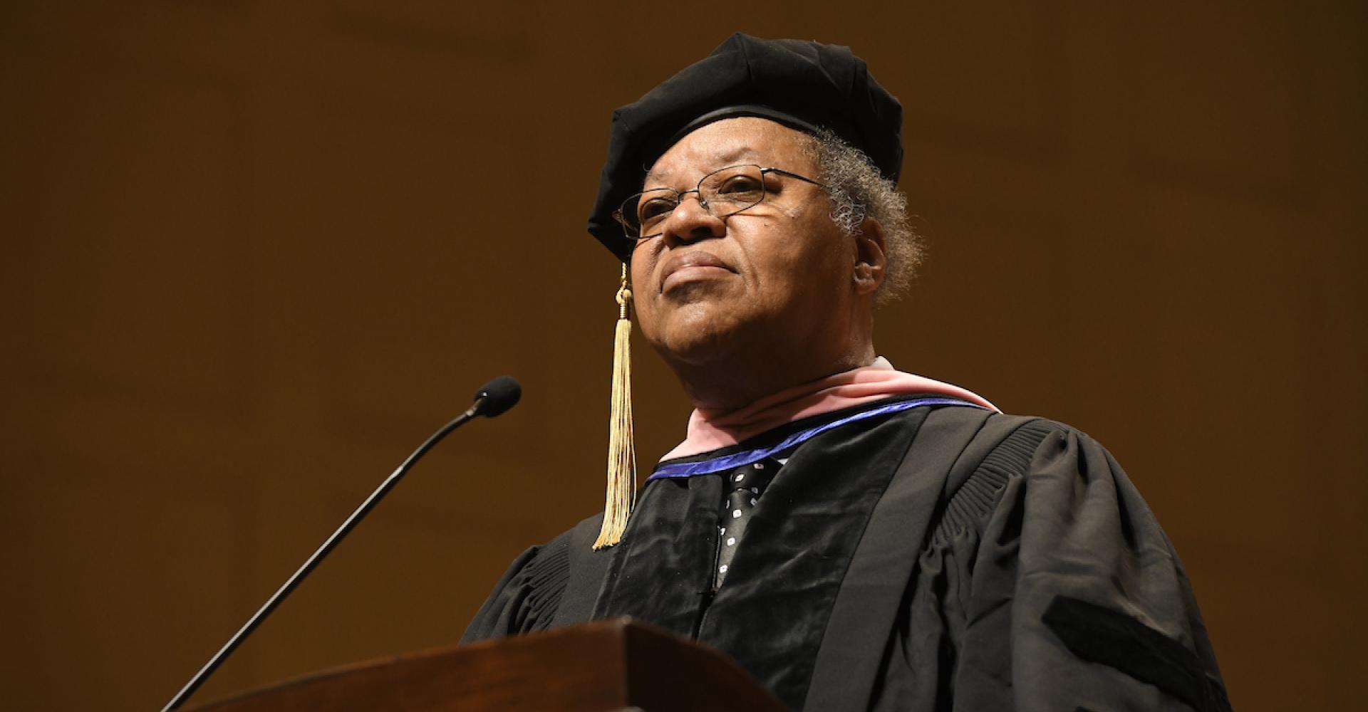 George E. Lewisa wears doctoral regalia and addresses the class of 2023 from the stage at Symphony Hall