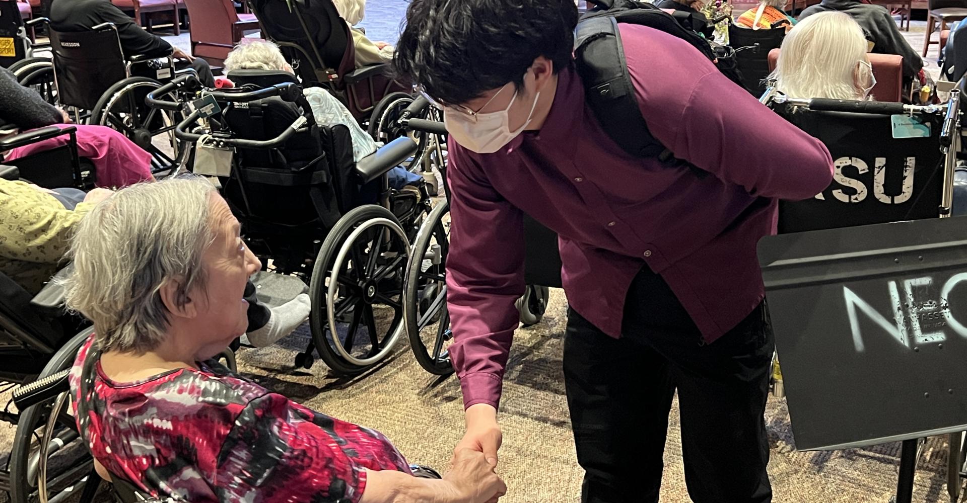 NEC student shaking hands with a senior resident. 