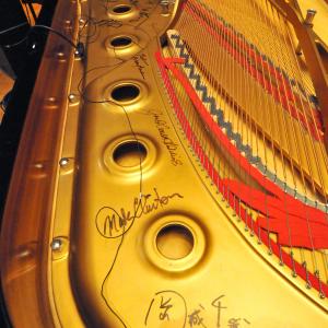 Autographs line the interior of one of NEC's Steinway concert grands