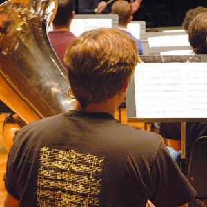 A tuba player rehearses with the NEC Wind Ensemble
