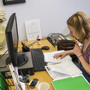 A work study student looks over music at her desk