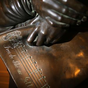 Close up of NEC's Beethoven statue, showing Beethoven's hand holding the score for the "Ode to Joy."