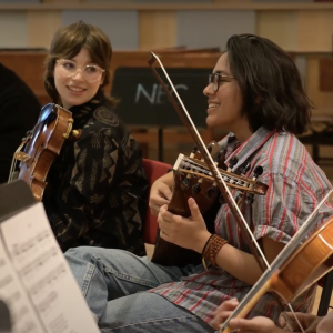 A violinist and an oud player wear casual clothes and rehearse during a Music of Turkey class